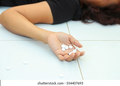 hand of girl who  wants to commit suicide by eating pills.