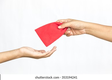 Hand Give Money In Red Pouch Bag To Someone For Chinese New Year On Isolated White Background