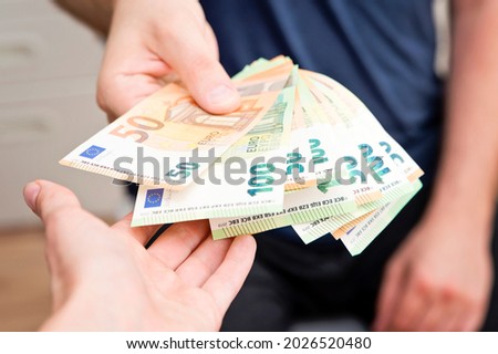 Hand gives bunch of Euros to other hand. Old style money transfer. Paying for services. Street  economy. Urban lifestyle. Imagine de stoc © 