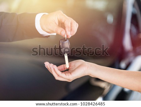 Hand giving car key