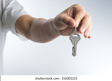 Hand giving keys on white background