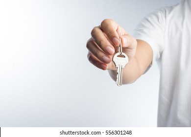 Hand Giving Keys On White Background