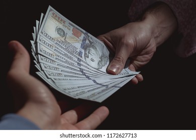 Hand giving money being received by another hand