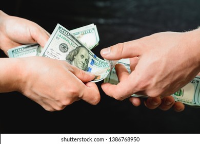 The hand, giving money, is isolated on a black background. - Powered by Shutterstock