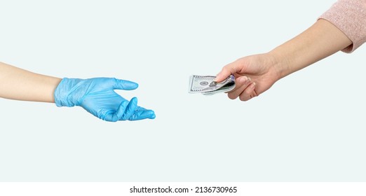 Hand giving money US dollars another hand in blue medical glove on grey background. Paid medicine. Costs for the medical insurance - Shutterstock ID 2136730965