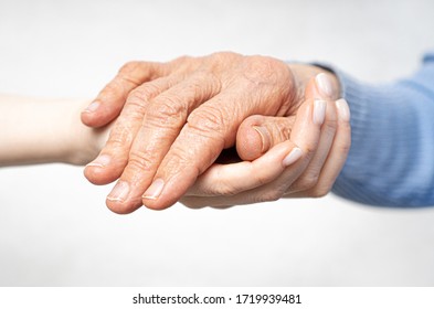 Hand Giving For Old Woman. Young Hands Hold Old Hands. Support For The Elderly Concept.