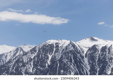 Hand glider soaring above the snow covered eastern Sierra Nevadas spring of 2023 - Powered by Shutterstock