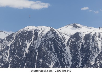 Hand glider soaring above the snow covered eastern Sierra Nevadas spring of 2023 - Powered by Shutterstock