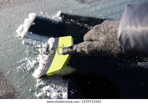 Hand in glove\
cleans window of the car from\
ice