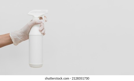 Hand With Glove Holding Cleaning Solution In Bottle With Copy Space