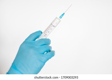 Hand in glove holding syringe with vaccine for virus
