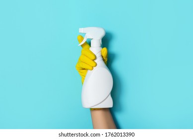 Hand in glove holding white plastic bottle of cleaning product, household chemicals. Copy space. Cleaning service concept. Household chemical cleaning products, brushes and supplies. Detergent bottle. - Shutterstock ID 1762013390