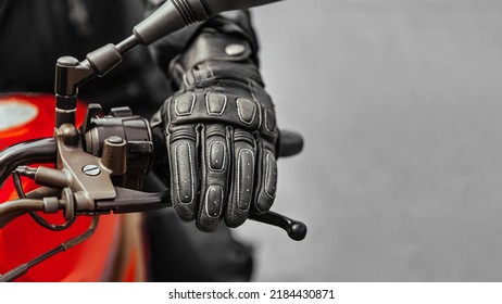 Mano en guante en el mango del freno de motocicleta, espacio libre para insertar