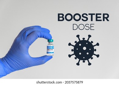 Hand in gloves holding vaccine for covid-19  Booster dose text and corona virus icon  - Shutterstock ID 2037575879