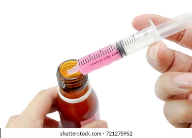 Hand Grab An Oral Syringe With Pink Liquid Medicine Inside For Children Patient With Medicine Bottle  Isolated On White Background