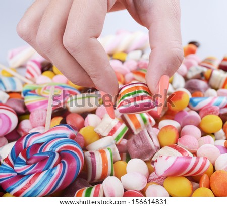 Hand grabbing candy from pile - Overweight problem concept