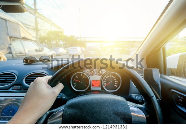 Hand grabbing steering wheel and drive to\
heavy traffic jam in morning rush\
hour.