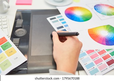 Hand from graphic designer in color design and pen   tablet   color wheel