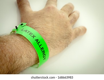 A Hand With A Green Latex Allergy Bracelet Around Wrist