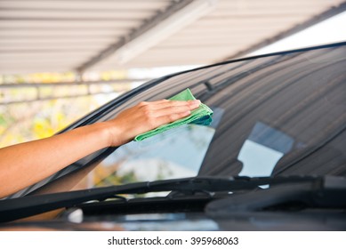 Hand With Green Microfiber Cloth, Cleaning Glass Car.
