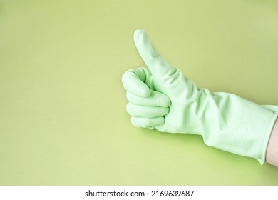 Hand In Green Rubber Glove Showing Thumb Up On Green Background For Design With Copy Space. Concept For Cleaning, Medicine, Hazardous Production.