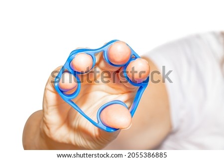 Hand Grip Strengthener in blue in the hand of a woman isolated on white background