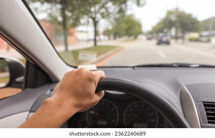 hand grips a car steering wheel, symbolizing safe and controlled driving, with a focus on responsibility and road safety - Powered by Shutterstock