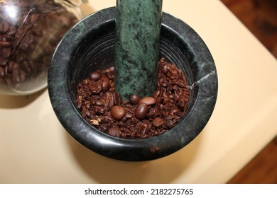 Hand ground coffee beans with a green marble mortar and pestle  - Powered by Shutterstock