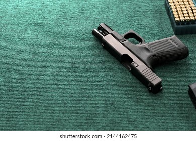 Hand Gun With Ammunition On Military Cloth Background, 9 Mm Pistol Gun Military Weapon And Pile Of Bullets At The Metal Table, Copy Space For Text Concept.