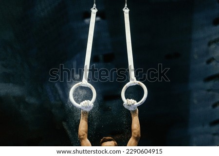 hand gymnast performing on ring frame competition artistic gymnastics, grips rings and gym chalk