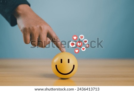 Hand with happy smiley face emotion on wooden circle. Customer service satisfaction, Positive thinking and mental health assessment, Happy client give feedback experience with rating very impressive.