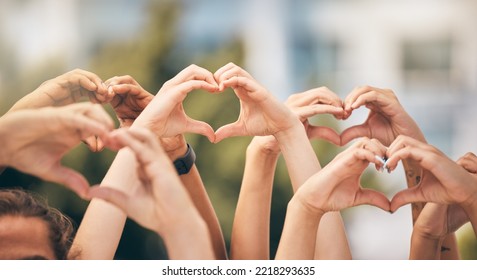 Hand, heart and love with a group of people making a sign with their hands outdoor together in the day. Crowd, freedom and community with man and woman friends doing a gesture to promote health