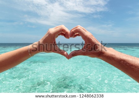 hand heart shape with Turquoise maldives water as background
