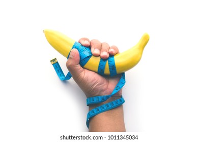 Hand held bananas wrapped with measuring tape - Healthy eating concept and slimming