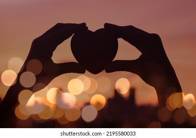 Hand Held Heart Against City Lights. Love And Hope Concept. 