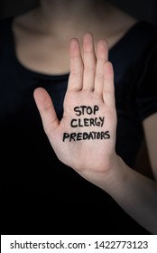 Hand Held Up In Stop Gesture With Words Stop Clergy Predators Written On Palm