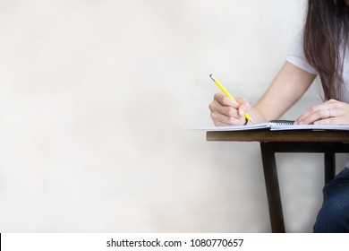 Hand High School Or University Student In Casual Holding Pencil Writing On Paper Answer Sheet.sitting On Lecture Chair Taking Final Exam Attending In Examination Room Or Classroom.