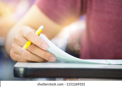 Hand High School Or University Student In Uniform Holding Pencil Writing On Paper Answer Sheet.sitting On Lecture Chair Taking Final Exam Or Study Attending In Examination Room Or Classroom