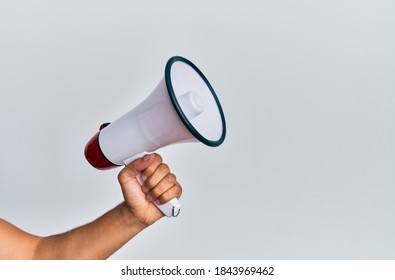 Hand of hispanic man holding megaphone over isolated white background.