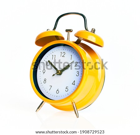 Hand of hispanic man holding yellow alarm clock over isolated white background.