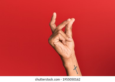 Hand of hispanic man over red isolated background snapping fingers for success, easy and click symbol gesture with hand  - Shutterstock ID 1955050162