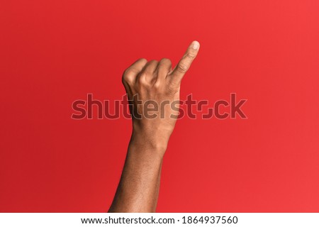 Hand of hispanic man over red isolated background showing little finger as pinky promise commitment, number one 