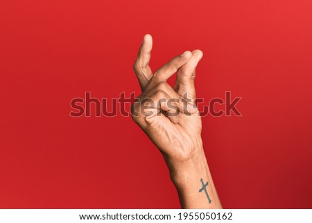 Hand of hispanic man over red isolated background snapping fingers for success, easy and click symbol gesture with hand 