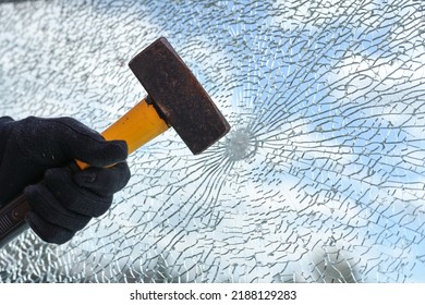 Man’s Hand Is Hitting A Window From Safety Glass With A Heavy Hammer, Vandalism And Burglary Concept, Copy Space, Selected Focus