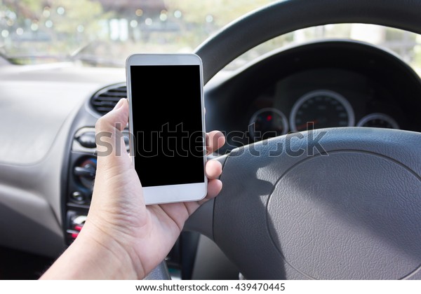 Hand hold blank\
screen smartphone inside car at driver seat, surfing internet or\
making phone call inside\
car