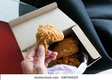 hand hold deep fried chicken from paper box
