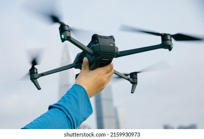 Hand hold a drone for landing in modern city