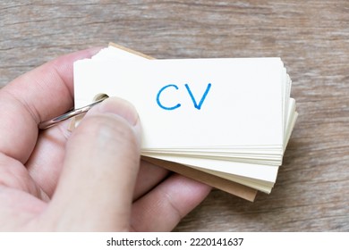 Hand Hold Flash Card With Handwriting In Word CV (Abbreviation Of Curriculum Vitae) On Wood Background