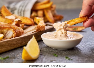 Hand hold a french fries and dips it in sauce tartar - Powered by Shutterstock