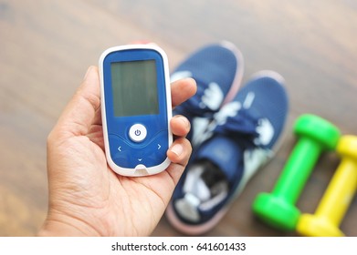 Hand Hold Glucose Meter.Diabetes Check Before Exercise Concept.